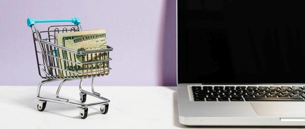 cart full of money alongside a laptop