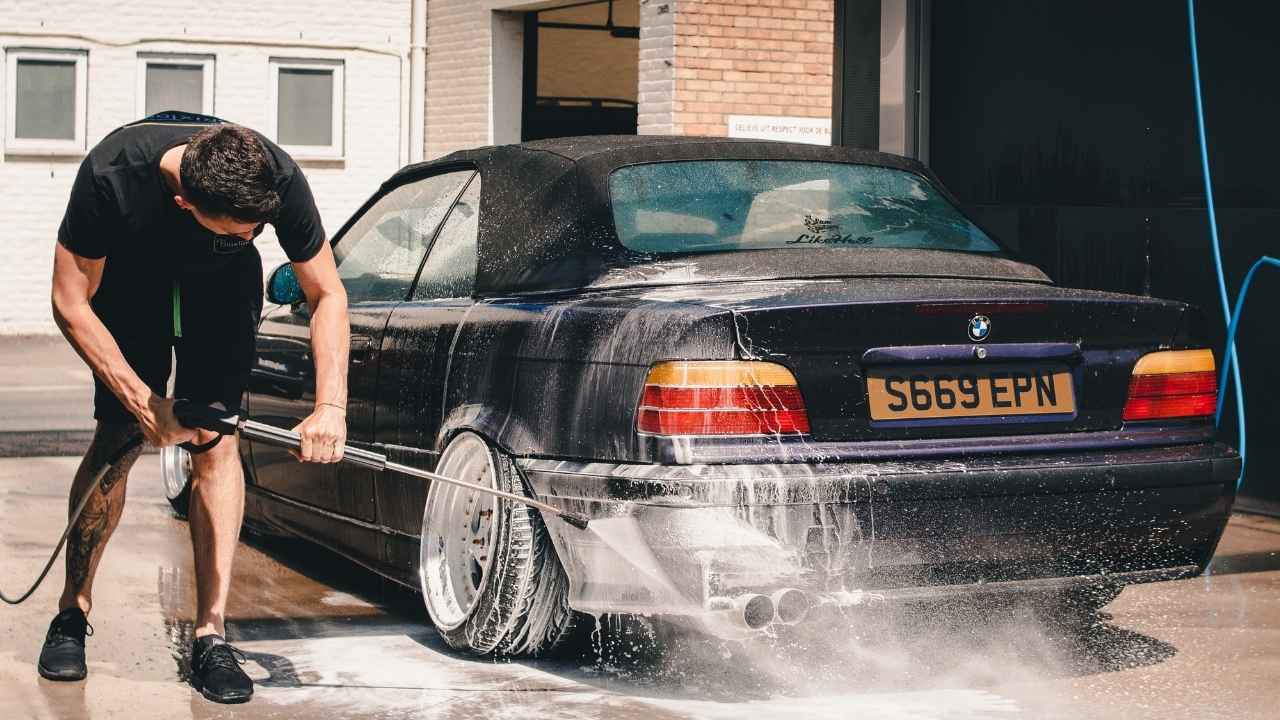 A guy washing his car with care