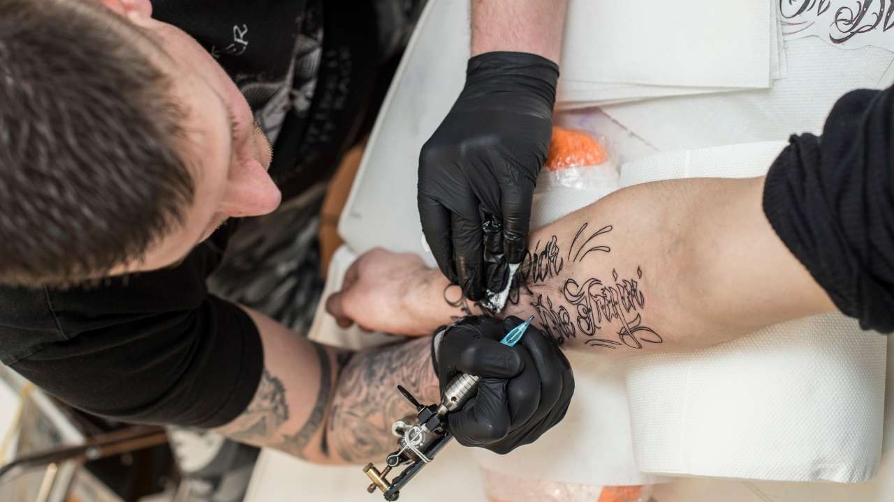 A guy getting a tattoo on forearm