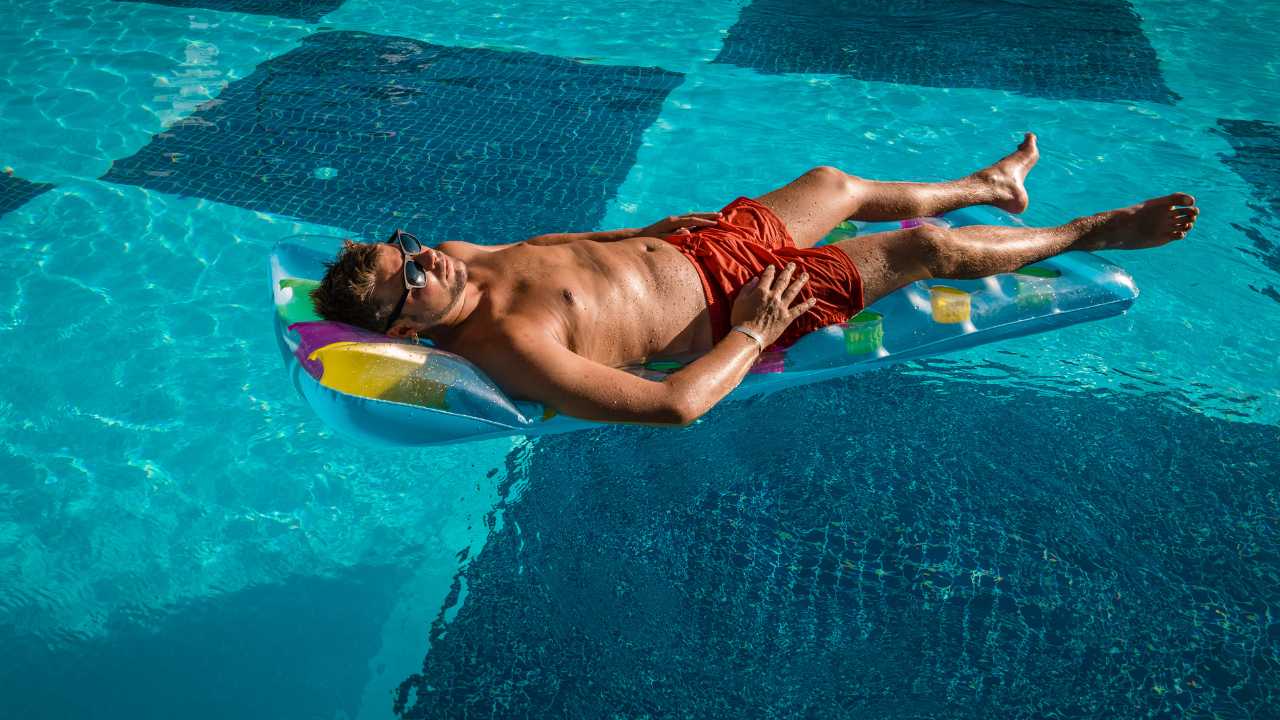 guy getting sun tanning in pool