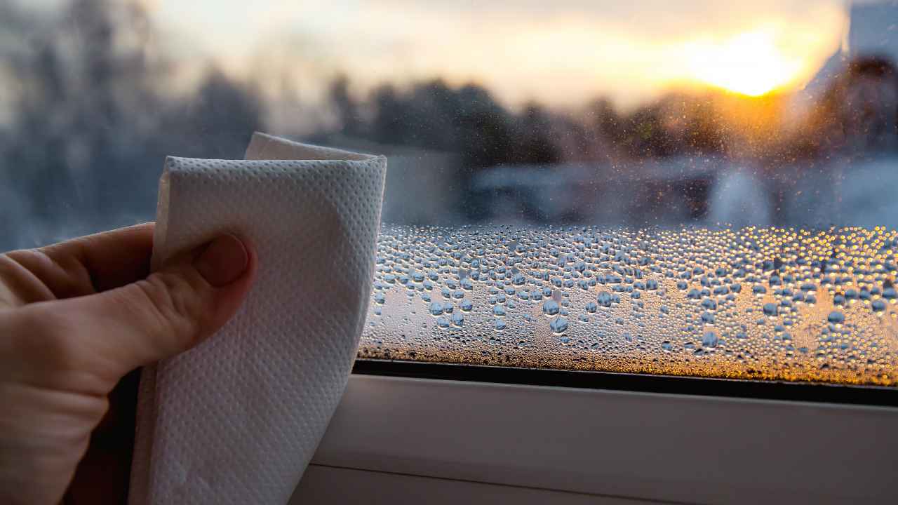 person wiping off Window Condensation